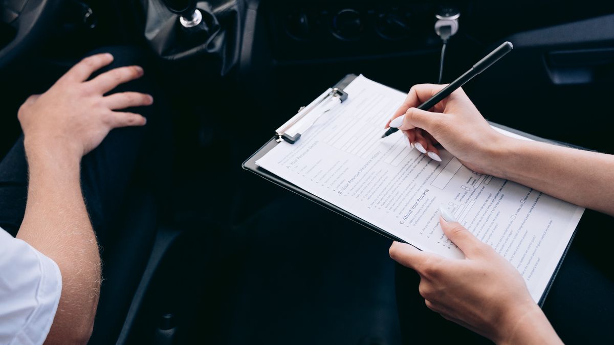A Louisiana driver completing an auto insurance application form inside a car