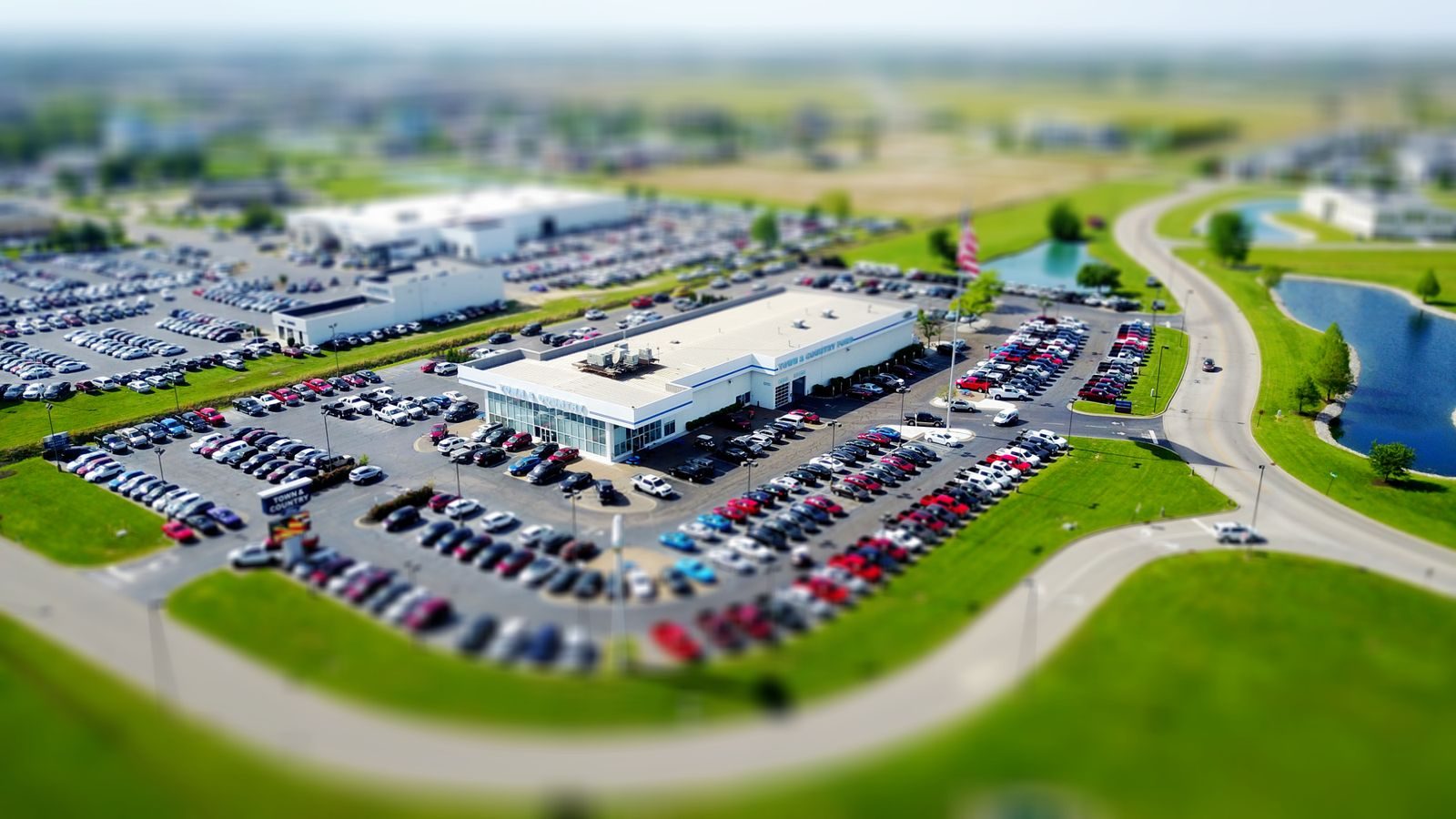 An aerial view of a car dealership lot full of new vehicles